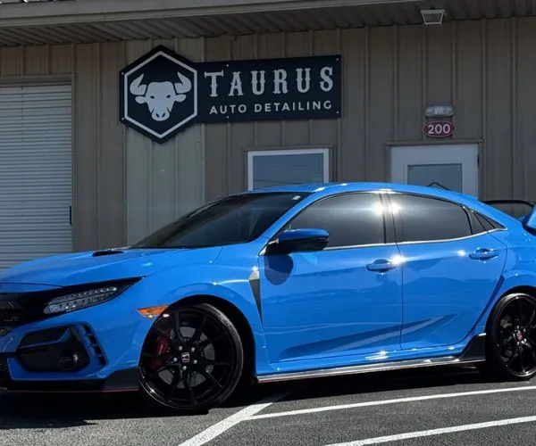 Side profile shot of a bright blue Honda Civic Type R in front of Taurus Auto Detailing.